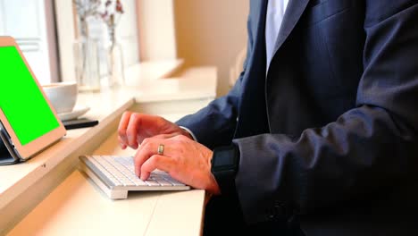 businessman typing on keyboard in cafã©