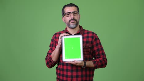 handsome persian bearded man showing digital tablet