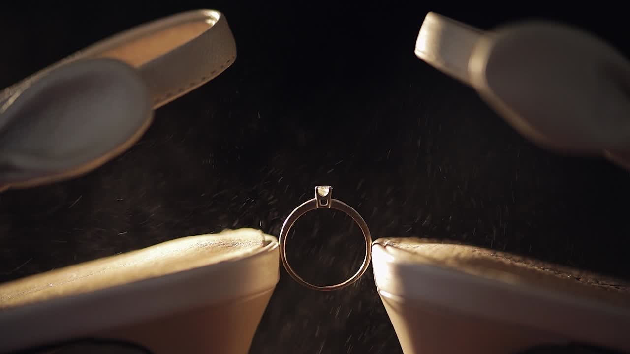 Engagement ring placed in between the brides wedding shoes. Spray of perfumes