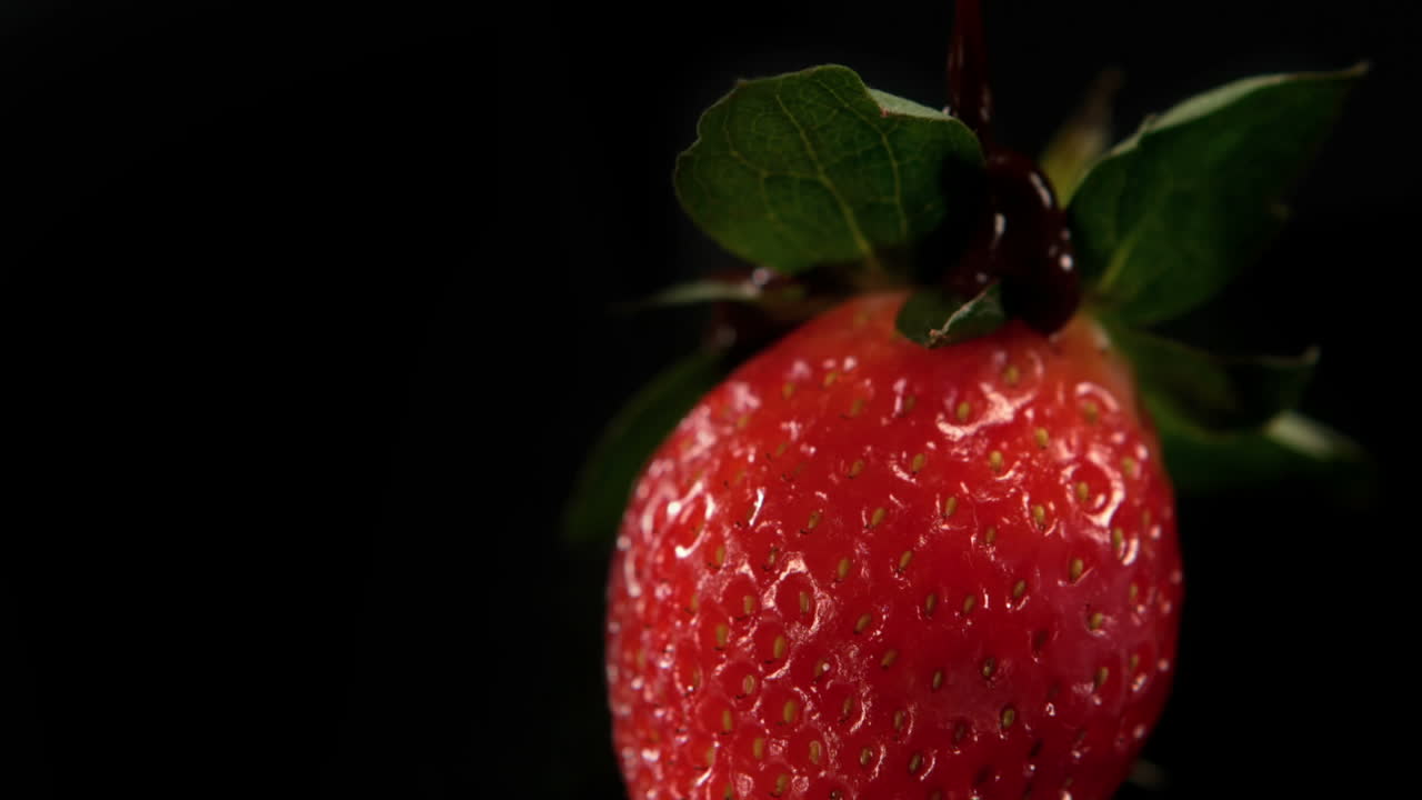 el chocolate derretido se vierte sobre la fresa.