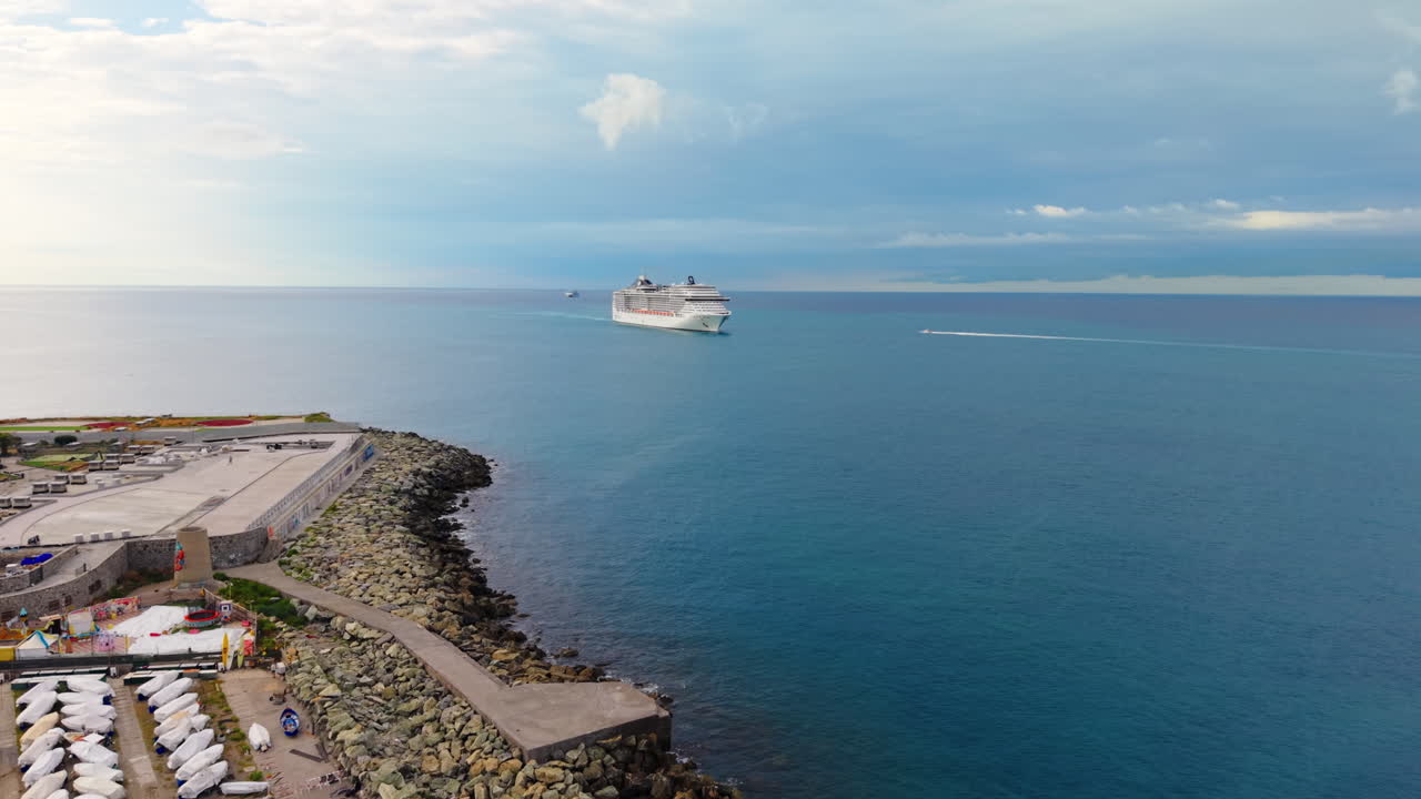 Drone advances from Genoa jetty toward cruise ferry as small motorboat approaches nearby