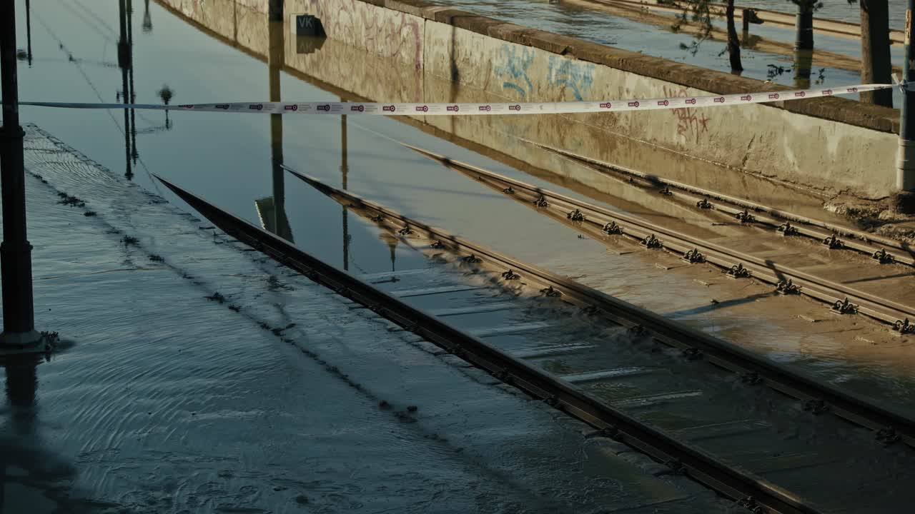 las vías del tranvía inundadas parcialmente sumergidas en el agua con cinta de precaución bloqueando el área durante la inundación de budapest 2024