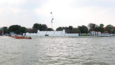 los barcos se mueven a lo largo del río chao phraya cerca del fuerte.