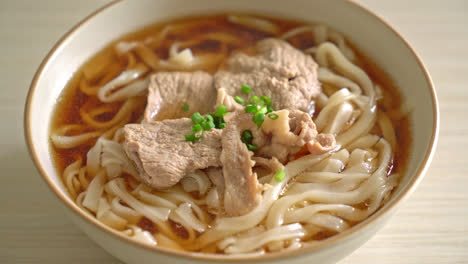 homemade udon ramen noodles with pork in soy or shoyu soup