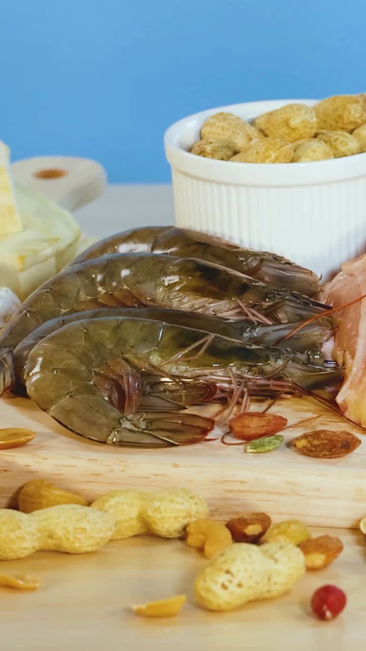 una variedad de alimentos ricos en proteínas, incluidas carnes, nueces y productos lácteos, están artísticamente dispuestos en una mesa con iluminación brillante