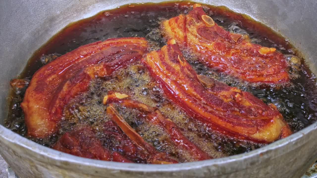 Sizzling pork rinds being prepared in a large caldero in Santiago, Dominican Republic