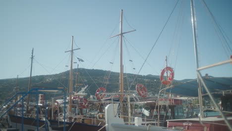 wide shot of boat masts with flags flapping in the wind in harbour