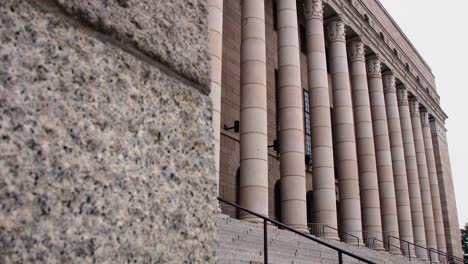 Vista-En-ángulo-De-La-Fachada-Del-Gran-Parlamento-De-Helsinki,-Columnas-Imponentes,-Cielo-Nublado