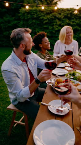 happy group toasting at an outdoor dinner party