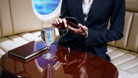 businessperson using smartphone on a private jet