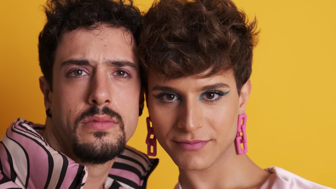 Man and trans man in makeup looking at the camera