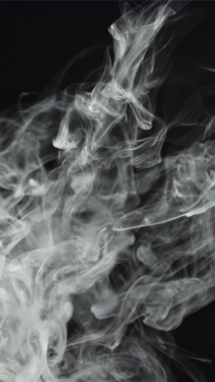 Fumo bianco che si innalza e turbina su sfondo nero
