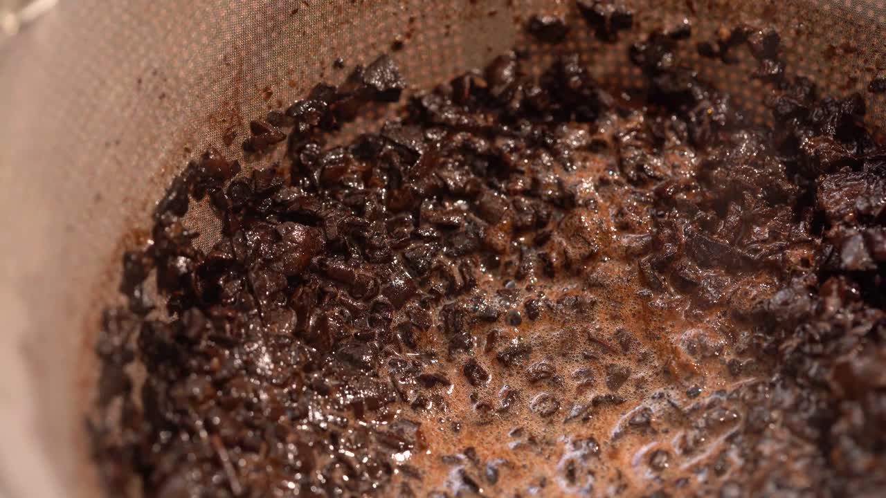 Nærbillede af kværnet kaffe, der suger vand til sig og laver kaffe.