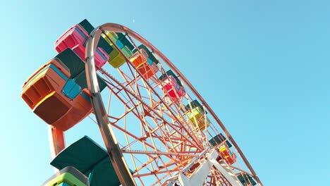 colorful ferris wheel turning under clear blue sky in boneless plaza, daytime joy ride