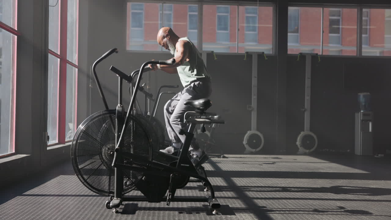 Man exercising on air bike in gym