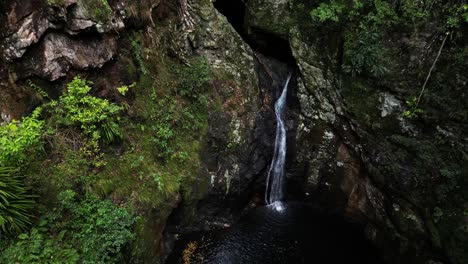 Wasser-Stürzt-In-Ein-Natürlich-Geformtes-Schwimmloch-Hinab,-Das-Tief-In-Einer-Tropischen-Dschungeloase-Versteckt-Ist