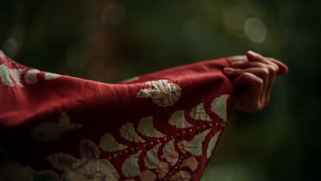 woman's hand holding a red kimono sleeve