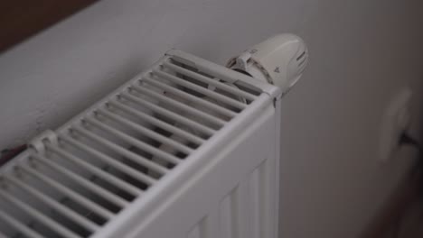 turning off radiator or heating, hand closeup, saving costs, economic crisis concept