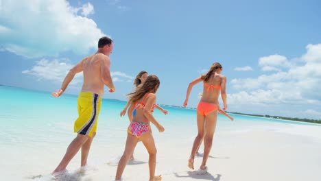 caucasian family in swimwear on tropical beach vacation
