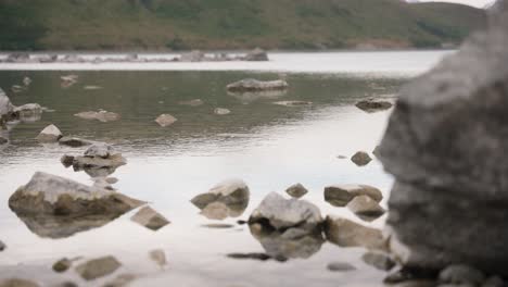 Lake-Tekapo-rain-drops-on-water-with-rocks-either-side