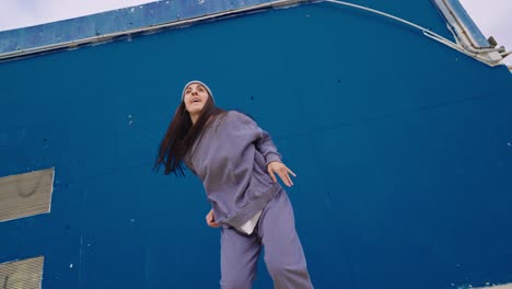 woman dancing in front of blue wall