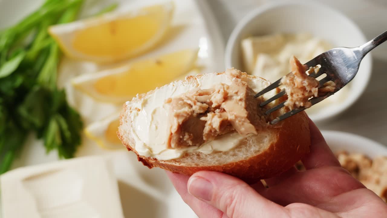 Smoked cod liver in oil in open tin can with fresh greens on wooden table. Seafoods delicacy. High quality 4k footage