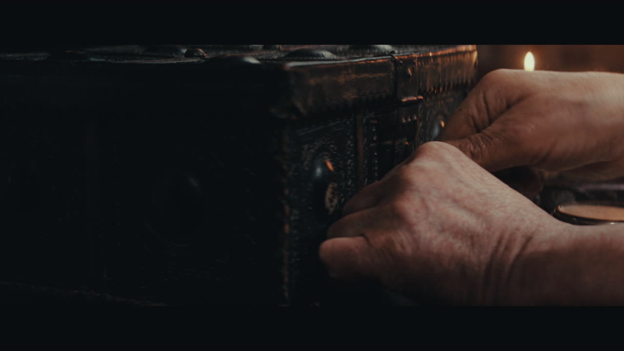 An old captain opens an old document chest inside the sailing ship cabin
