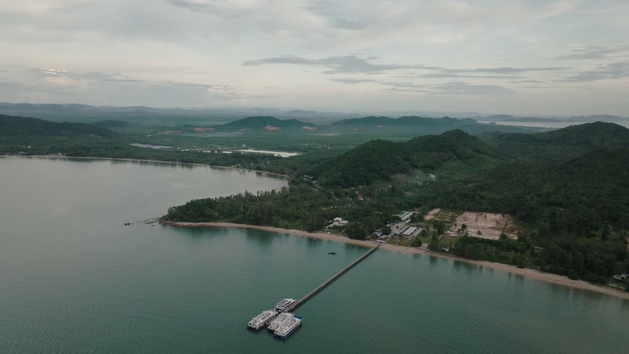 Aerial view of pier on coastline near Ko Tao, Thailand, with green hills inland