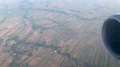 vista aérea del parque eólico a través de la niebla de la ventana de vidrio del avión en vuelo