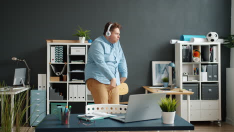 man dancing in office during video call