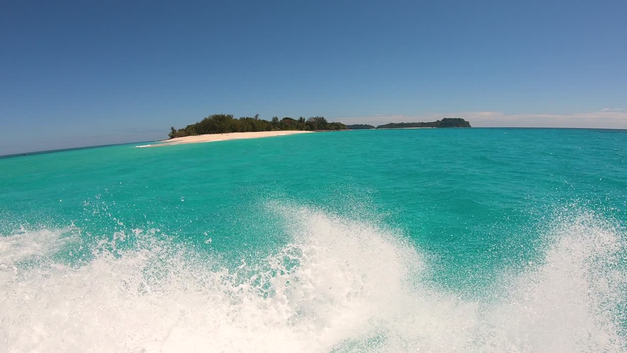 배를 향해 충돌하는 파도 사이에 열린 바다에서 완전한 속도로 이동하는 배의 입니다.