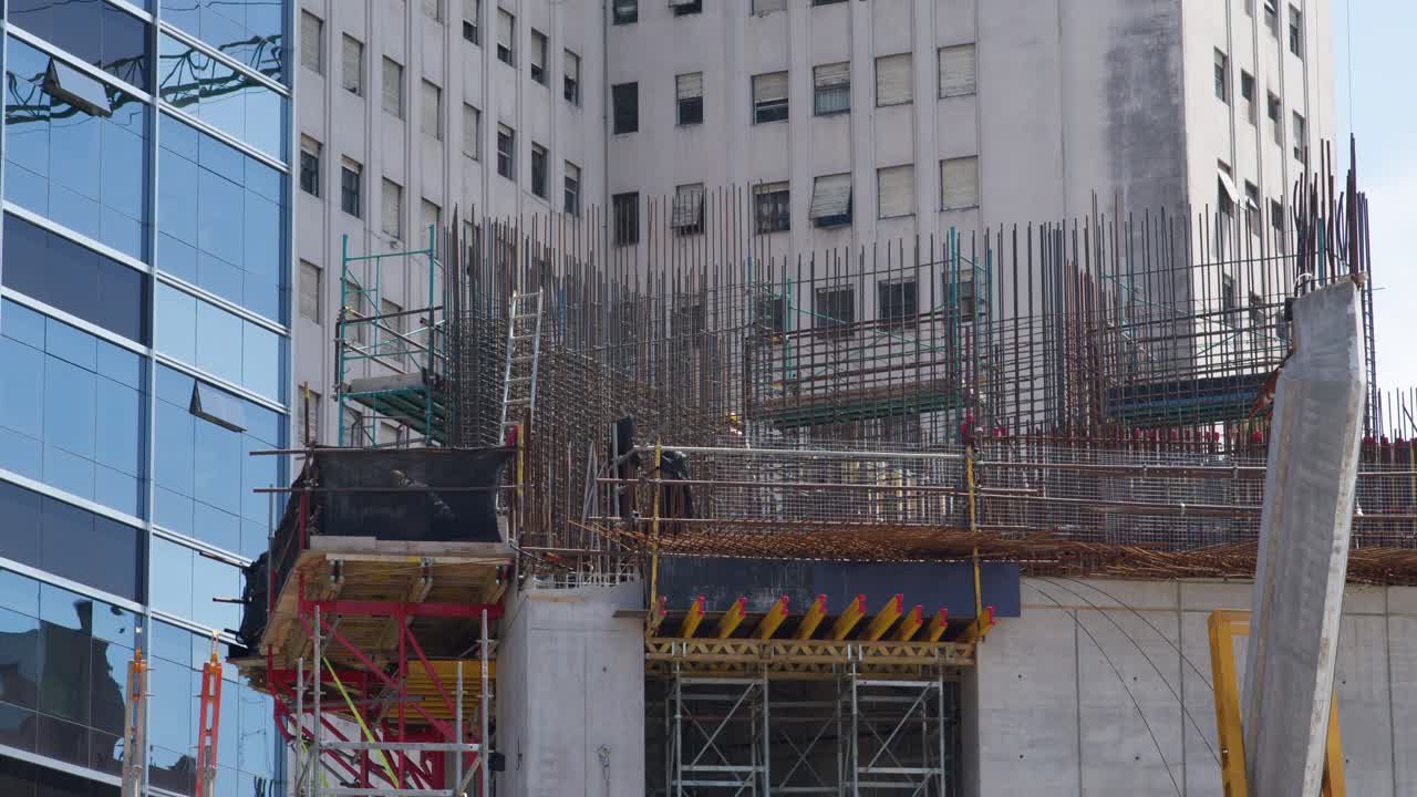 primer plano de un edificio en construcción en argentina, con andamios y grúas en acción