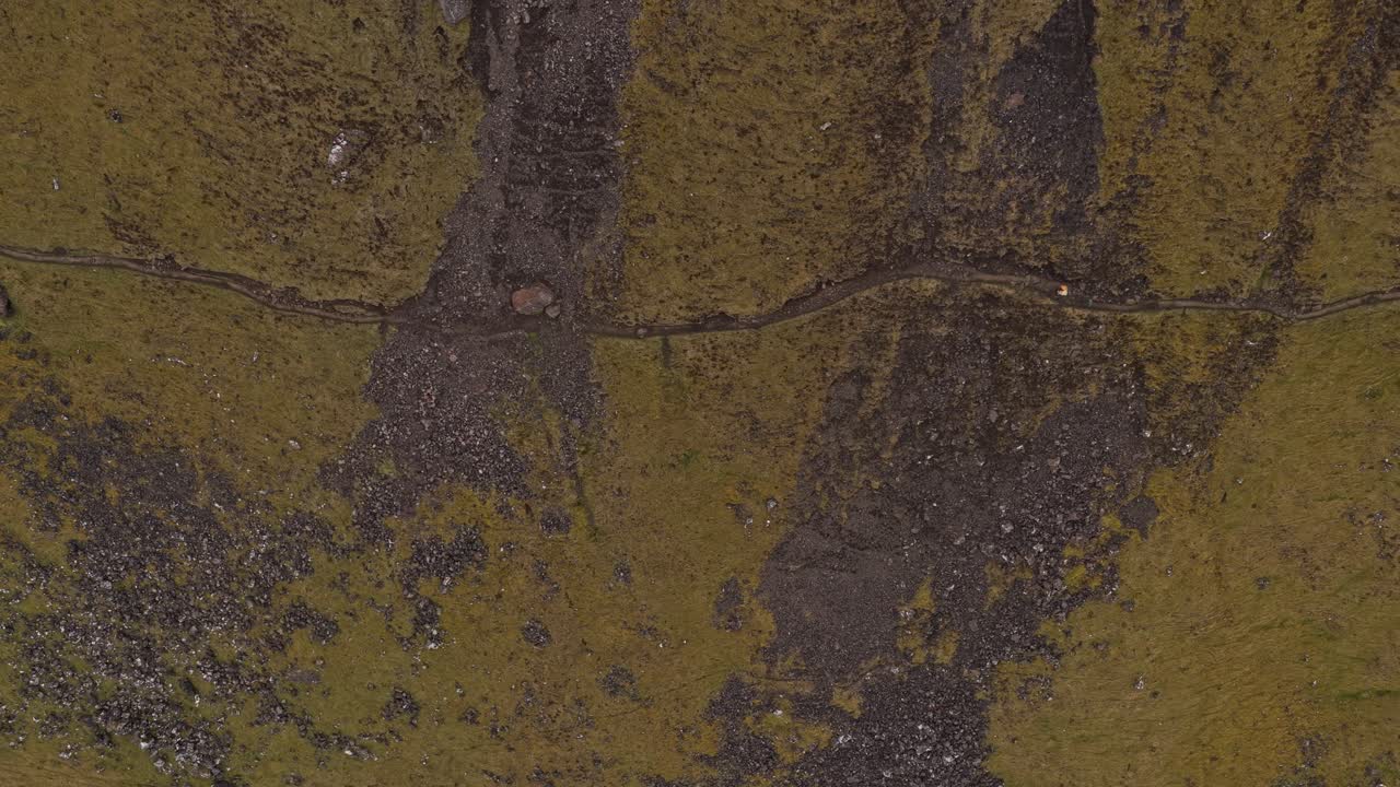 Person walking along a narrow mountain path in scotland