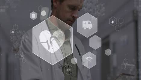animación de iconos médicos sobre un médico caucásico usando una tableta digital en el hospital.