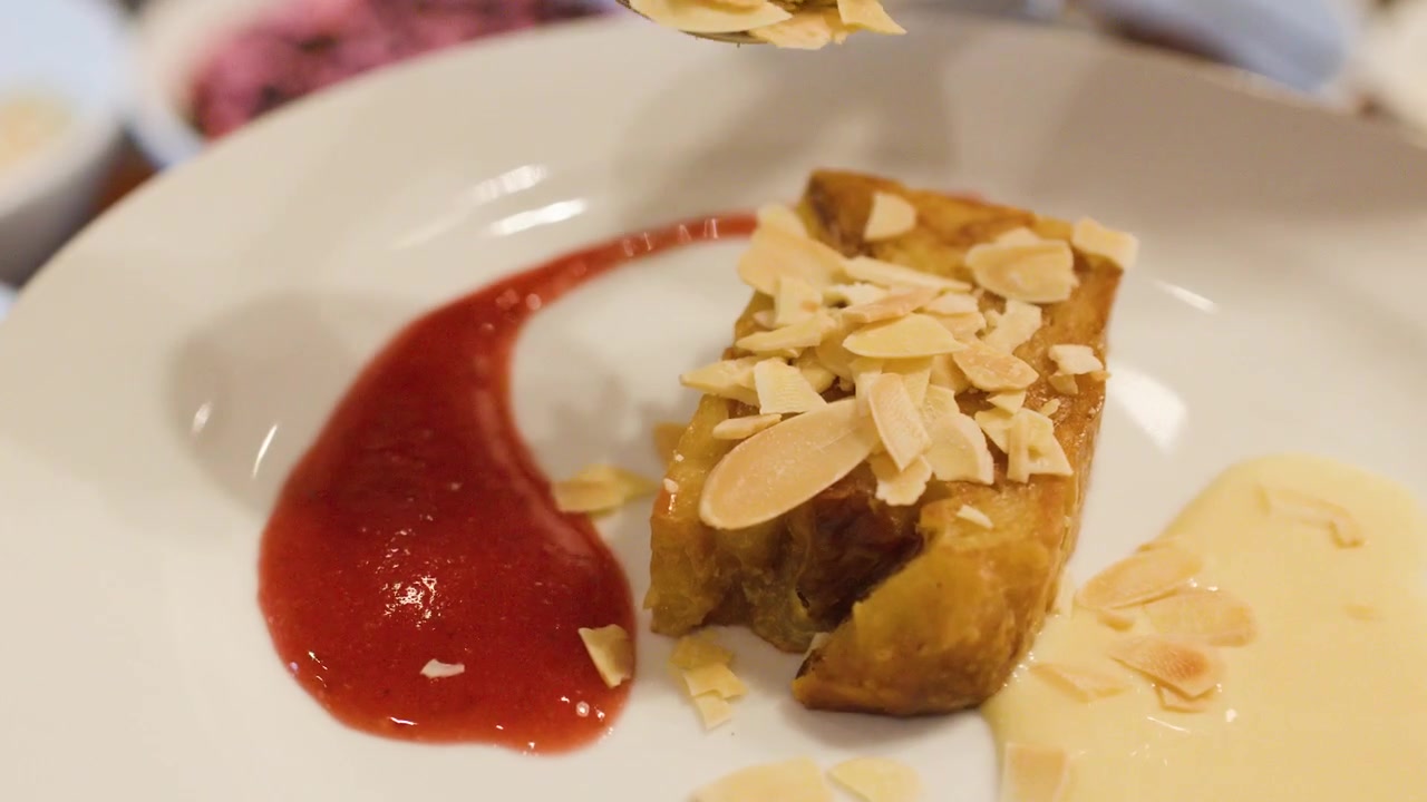 Chef Garnishing a Slice of Dessert with Toasted Almonds