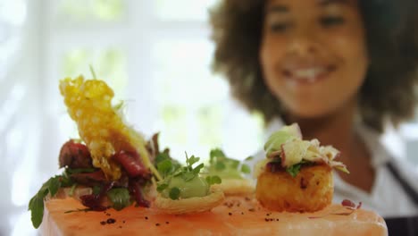 Smiling-waitress-holding-food-tray