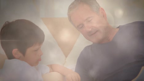 animation of light spots and trails over diverse senior man and grandson reading books