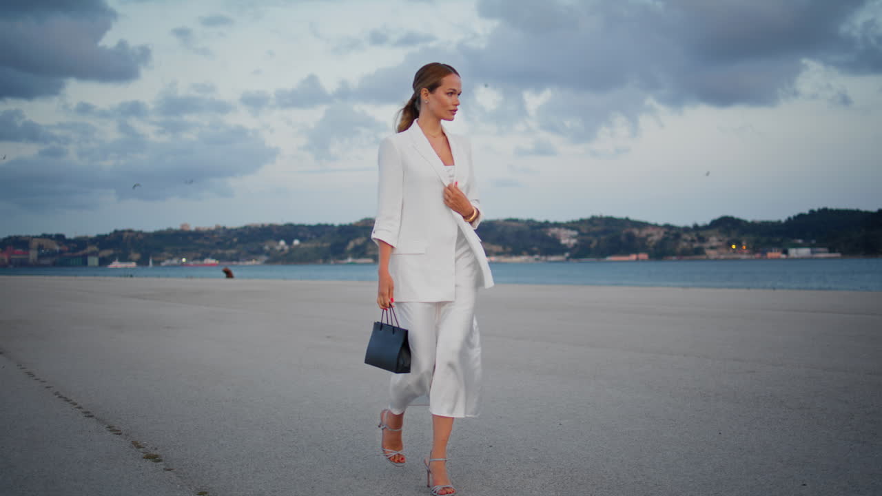 mujer de negocios que va a una reunión con un traje elegante. mujer de negocio caminando por la orilla del mar.