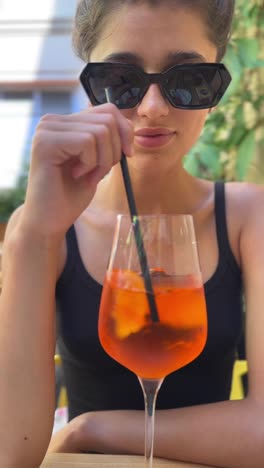 young woman enjoying an aperol spritz in a cafe