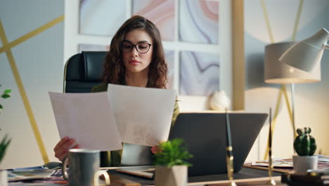 young woman entrepreneur analysing papers at office close up. businesswoman work