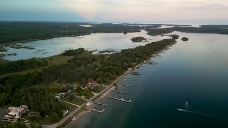 Aerial-high-descent-of-Hessel-Point-and-boats-on-water,-Les-Cheneaux-Islands,-Michigabn