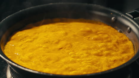 yellow boiling sauce on pan close-up. asian cuisine concept. curry is a dish with a sauce seasoned with spices. curries may contain fish, meat, poultry, or shellfish, either alone or in combination with vegetables. others are vegetarian.