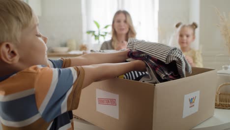 Tracking-video-of-boy-with-clothes-for-donation