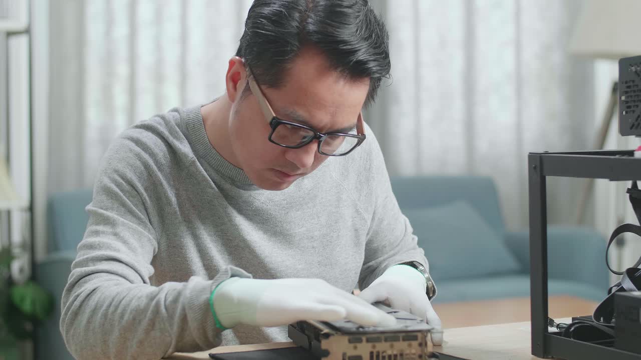 안경을 쓴 아시아 남자가 암호화폐를 채굴하기 위해 광산 기계를 고 있다.