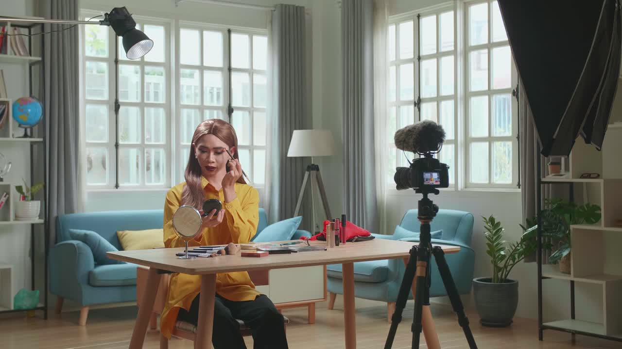 Influencer Young Transgender Woman Blogger Talks About Makeup. Transgender Woman Recording Video Blog Tells How To Be Beautiful. Blogger Talks Facial Beauty Treatments. Vlogger Broadcasts How To Use Of Cosmetic In Home Studio With Professional Lighting Equipment