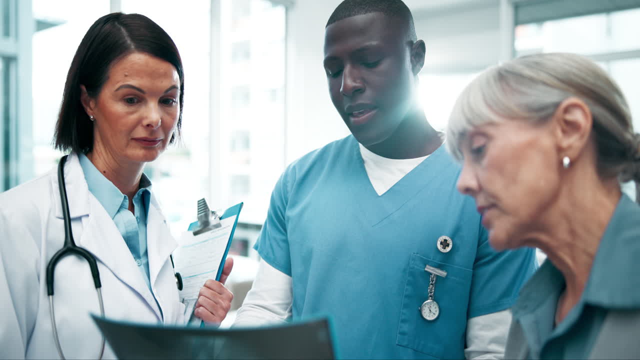 Doctors and nurse consulting with patient over x-ray