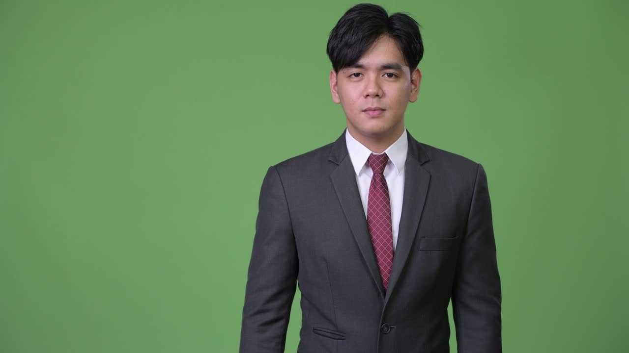 무언가를 보여주는 젊은 잘생긴 아시아 사업가