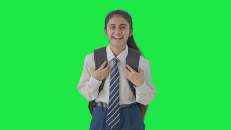 chica de la escuela india feliz riendo de alguien en la pantalla verde
