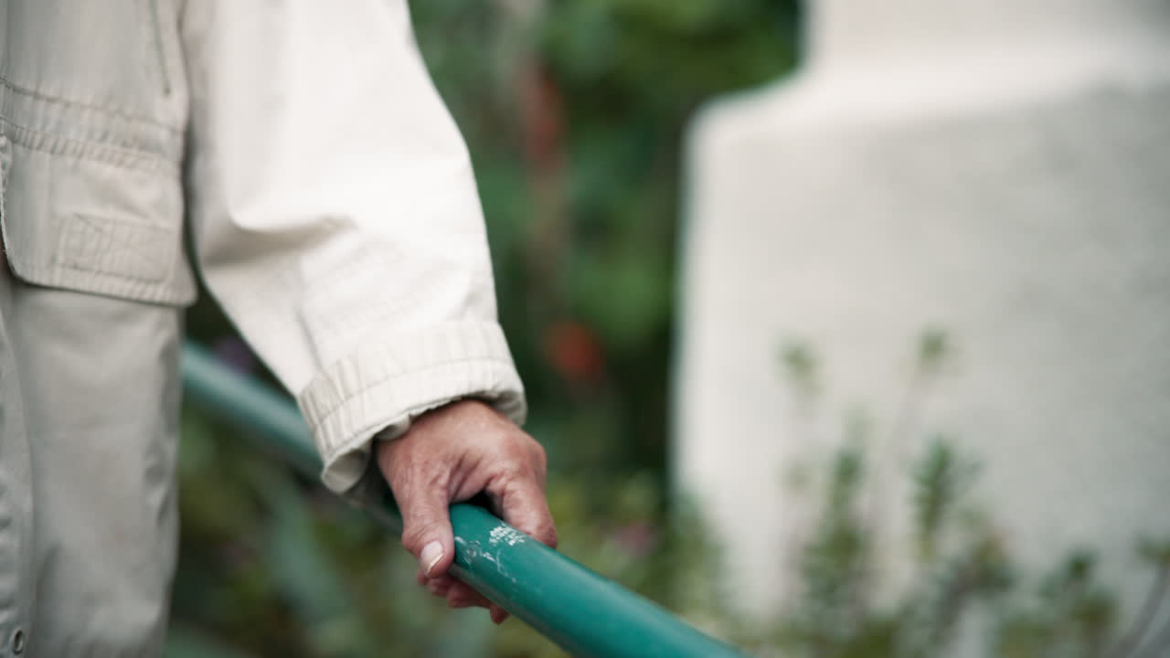 Hand Holding a Green Railing