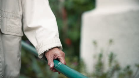 hand holding a green railing